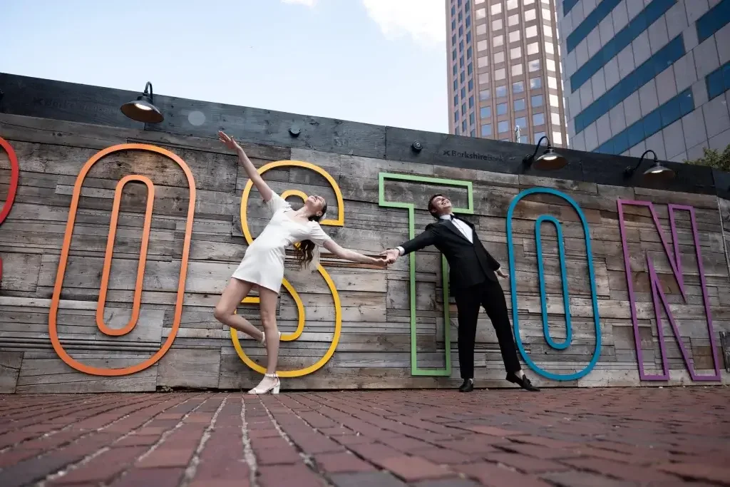 photo of a couple in front of the Boston sign